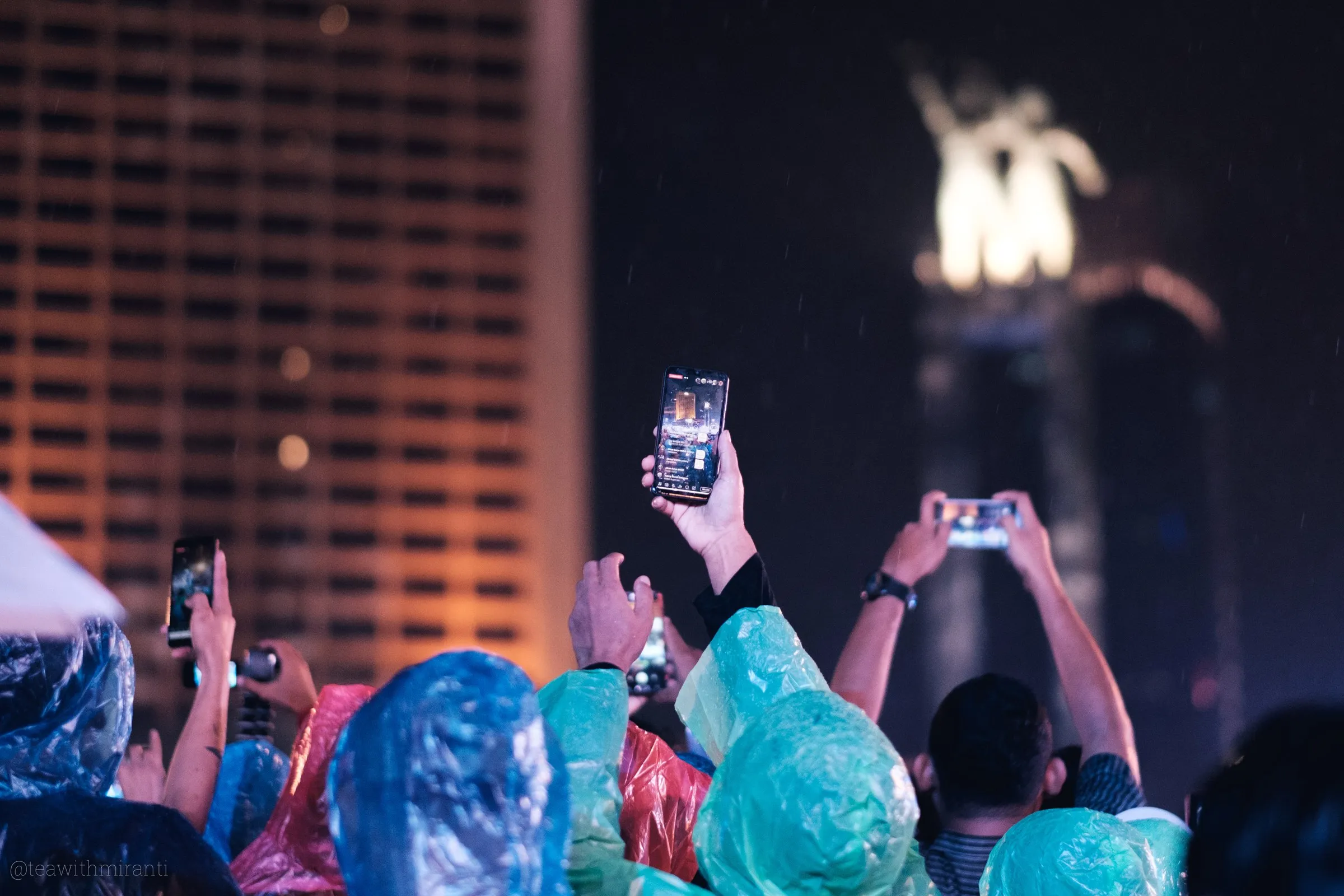 People recording the event with their mobile phone under the rain